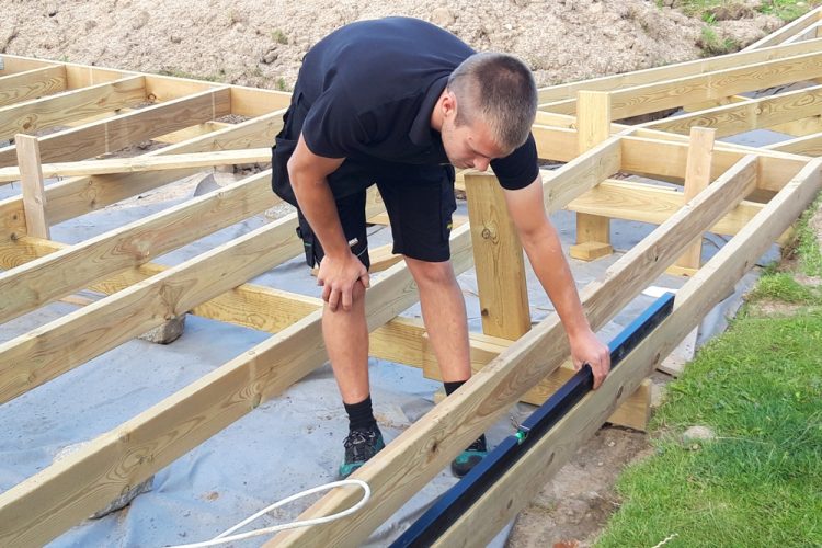Carpenter leveling a large deck.