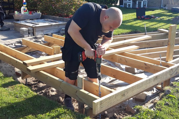 Carpenter installing a screw pile foundation.