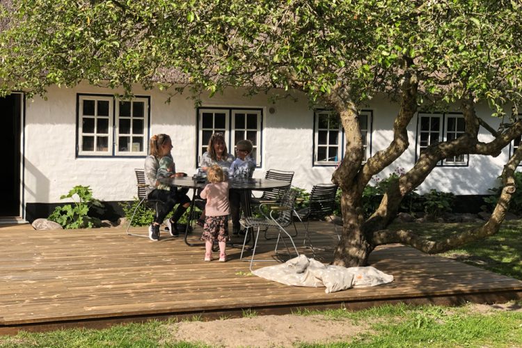 Family-time on a new wooden deck with an old apple tree build in.